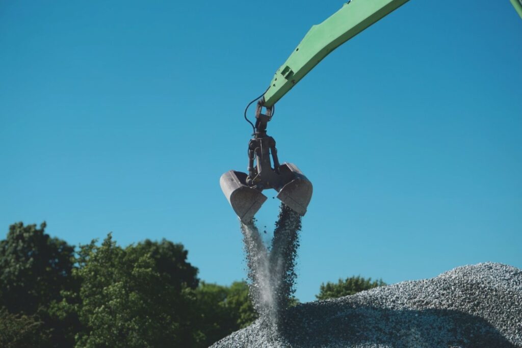 Verladung von Schotter mit Greifer für den Umschlag und Transport von Baustoffen.